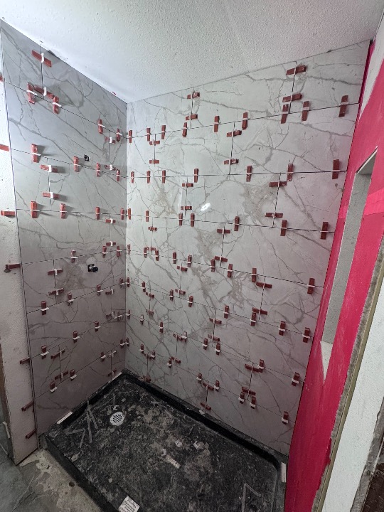 Contractor installing tile during a home bathroom renovation