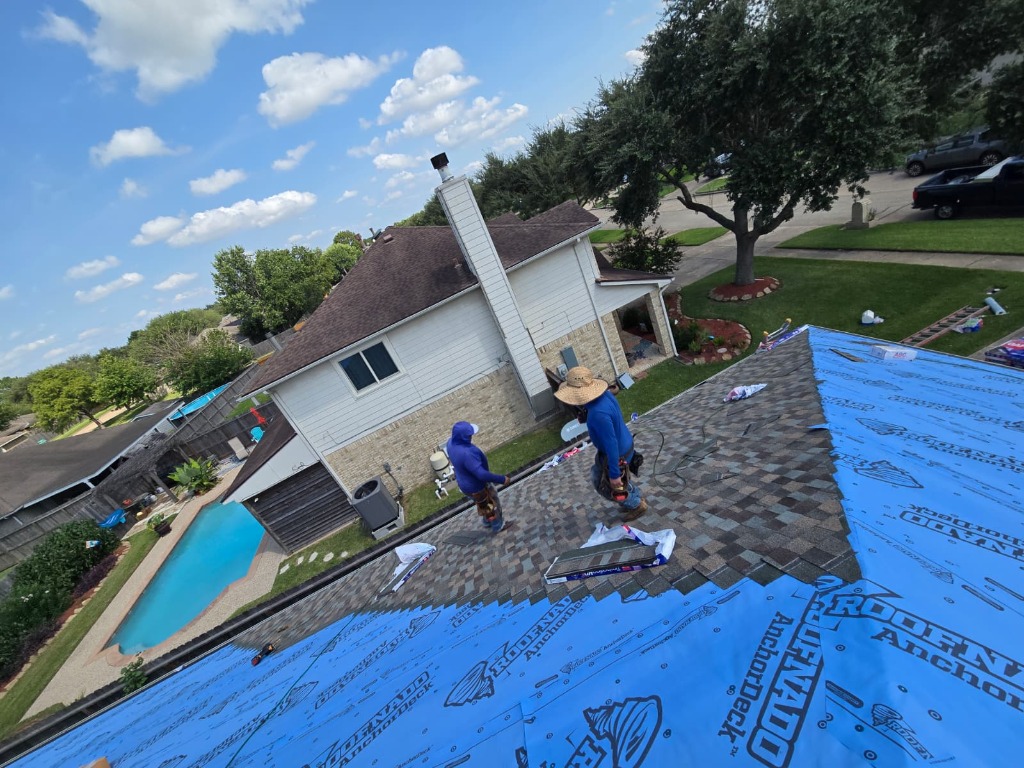 Family-owned roofing team standing proudly in front of a completed roof replacement in Houston